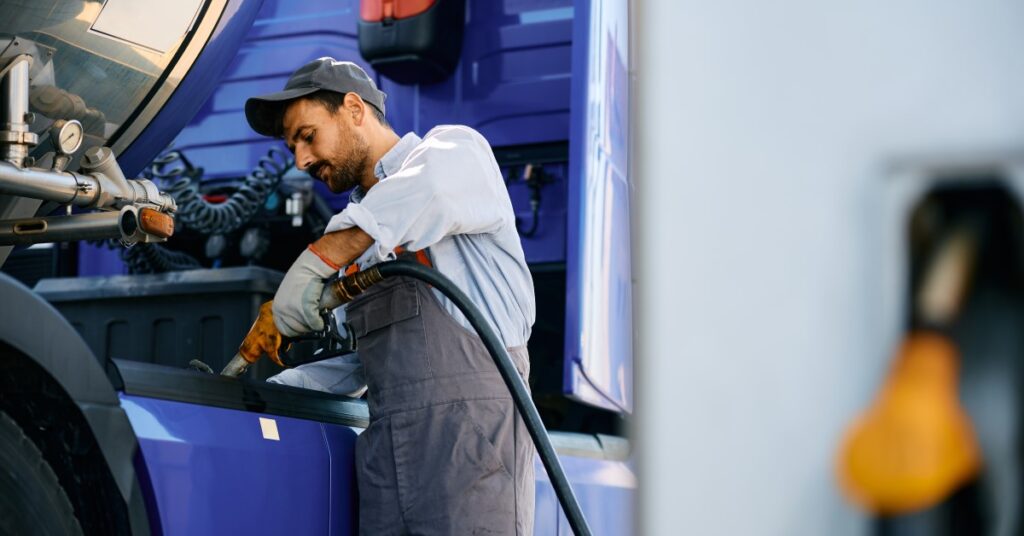 Man filling his blue semi truck with diesel fuel